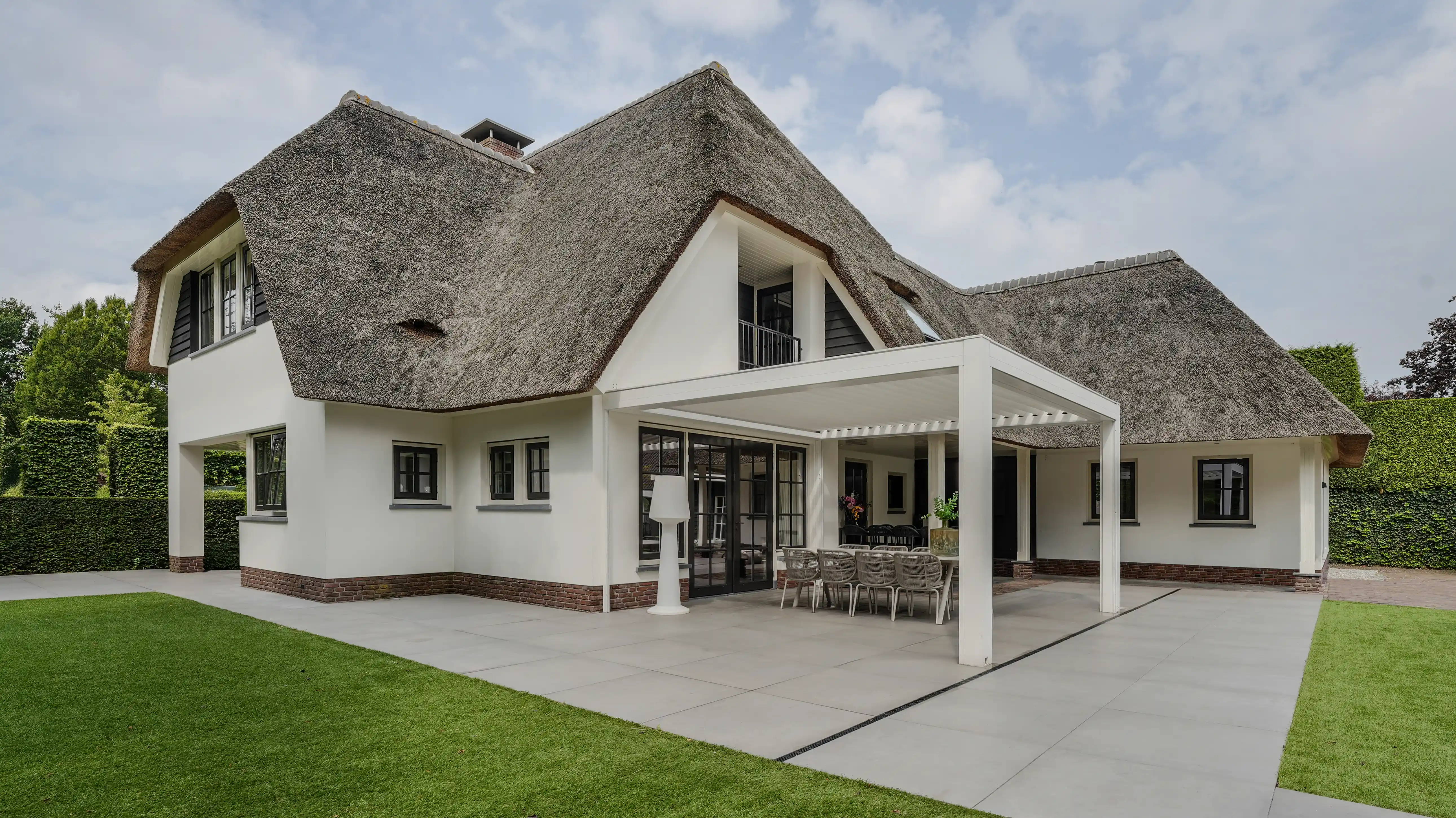 Witte lamellentuinkamer bij een rietgedekte villa in Nijkerk | Artino
